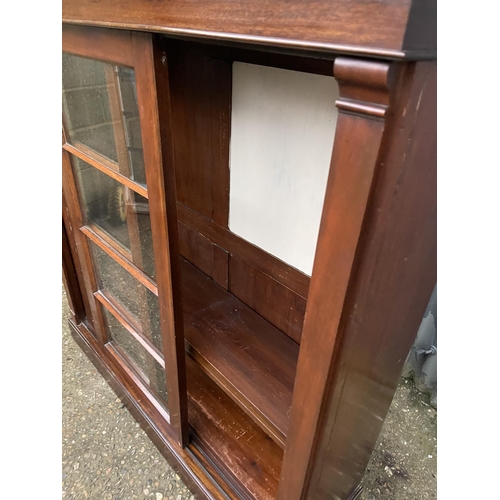 260 - A mahogany bookcase with ajdustable shelves and two glazed sliding doors