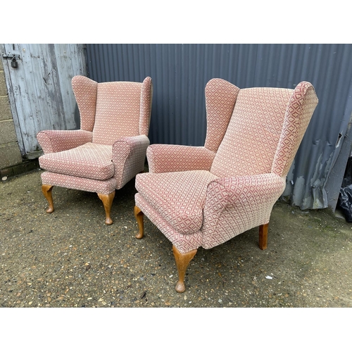 40 - A pair of red and gold upholstered wing back armchairs