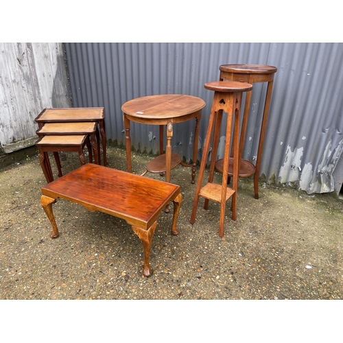 41 - An oval mahogany occasional table two plant stands, a rectangular table and a nest of three