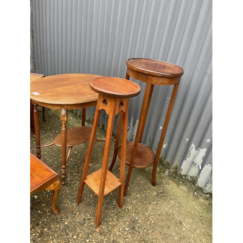 41 - An oval mahogany occasional table two plant stands, a rectangular table and a nest of three