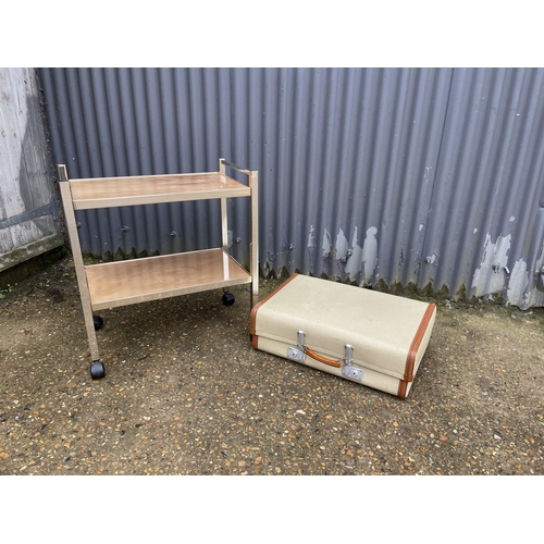 46 - A retro two tier tea trolley, together with a revelation suit case