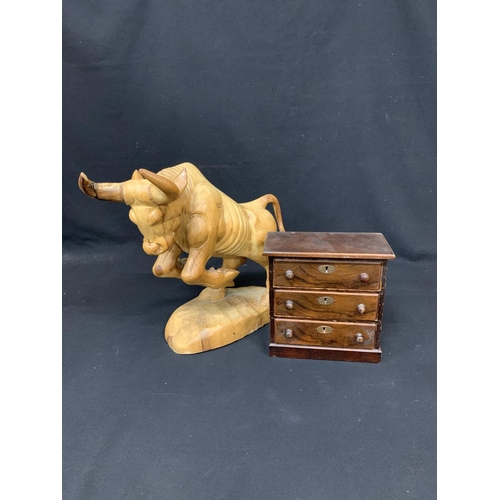 559 - Carved wooden bull and miniature chest of three drawers