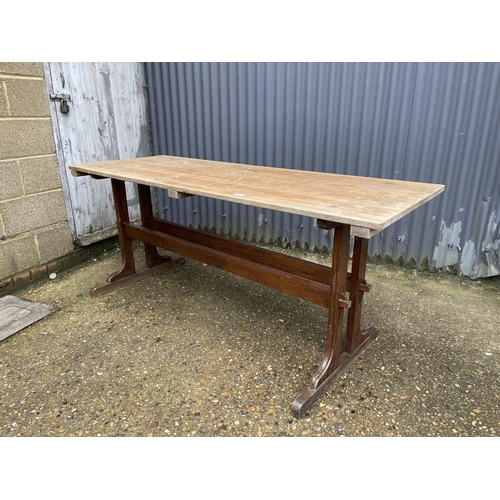 289 - A refectory style dining table with pine top and oak stretcher base 180x66x79