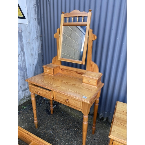 110 - A pine dressing table together with  three pine racks and a bedside