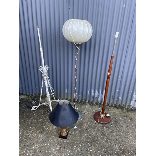 140 - Three mid century floor lamps and a wooden table lamp