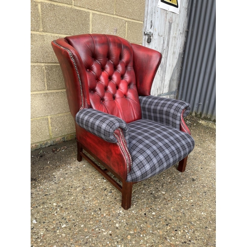 18 - A red leather chesterfield wing back armchair with blue tartan upholstery to arms and seat