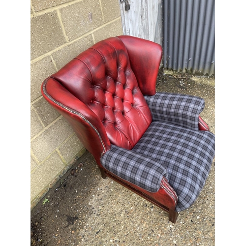 18 - A red leather chesterfield wing back armchair with blue tartan upholstery to arms and seat