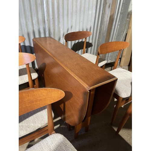 196 - A mid century teak gate-leg dining table together with a set of six matching teak chairs