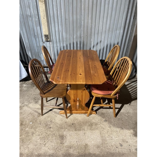 204 - A pine refectory style table together with four stick back kitchen chairs