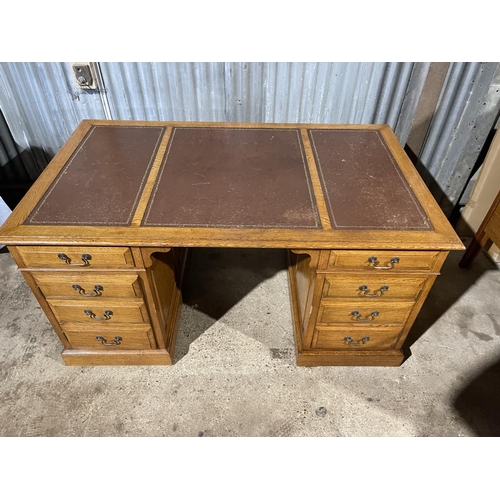 212 - A oak twin pedestal office desk with two drawers and two cupboard doors and a brown three section le... 