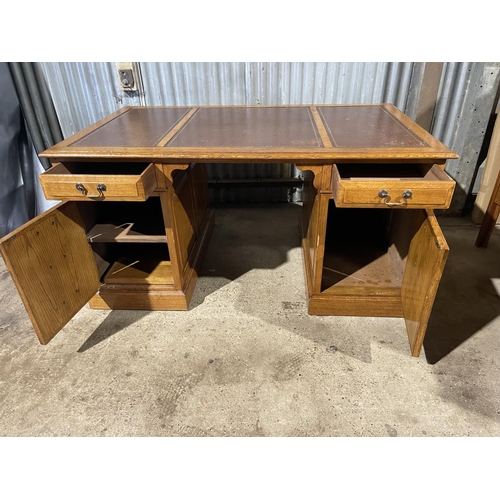 212 - A oak twin pedestal office desk with two drawers and two cupboard doors and a brown three section le... 