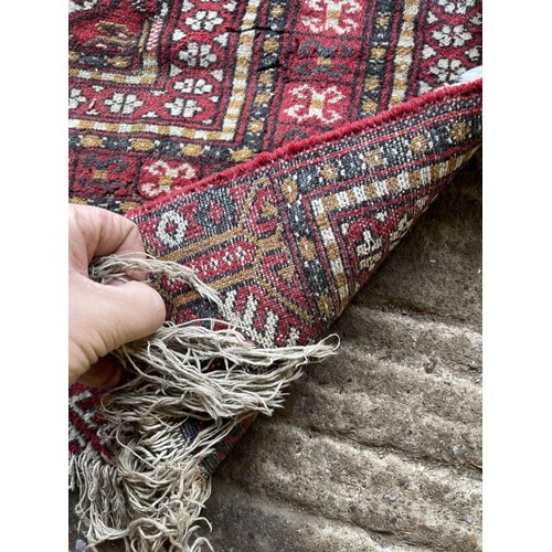 225 - A worn red oriental pattern rug 167x70 together with a small red and green pattern rug