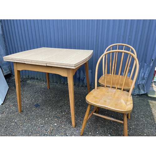 265 - A formica draw leaf kitchen table and two stick back chairs