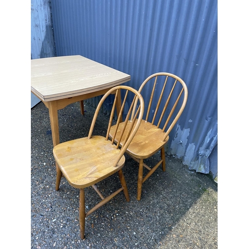 265 - A formica draw leaf kitchen table and two stick back chairs