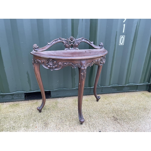 303 - An ornate mahogany Demi lune hall table