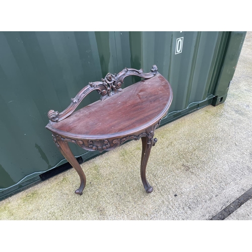 303 - An ornate mahogany Demi lune hall table