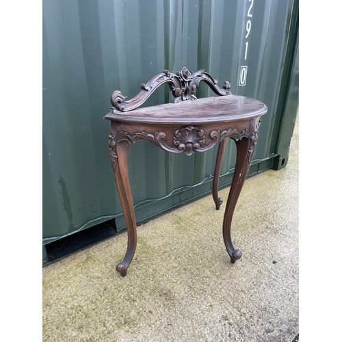 303 - An ornate mahogany Demi lune hall table