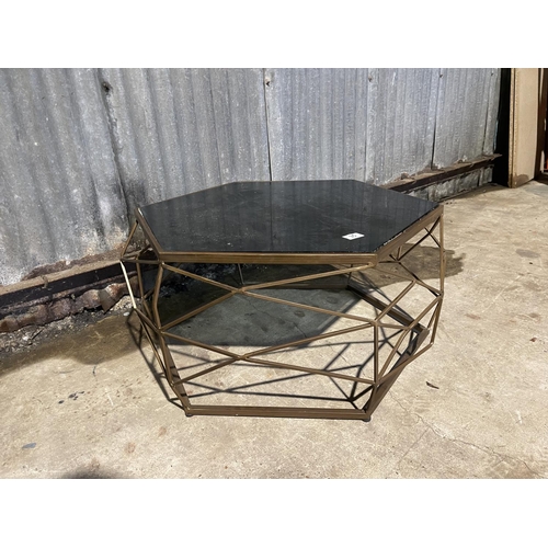 35 - A hexagonal brass coffee table of geometric design with smoked glass drop in top