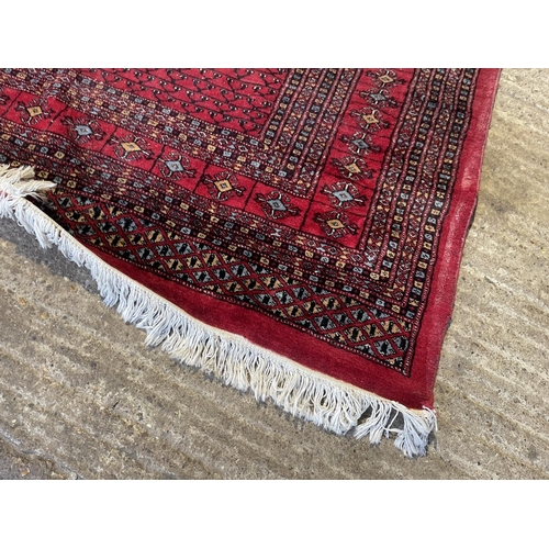 69 - A large red oriental pattern carpet 380x285