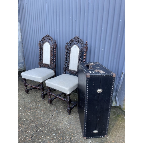 91 - A pair of carved oak chairs, together with a vintage case