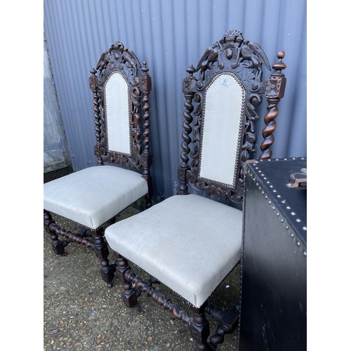 91 - A pair of carved oak chairs, together with a vintage case