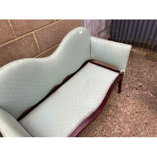 171 - An Edwardian mahogany love seat upholstered in green 112cm wide