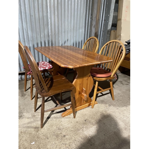 89 - A pine refectory style table together with four stick back kitchen chairs