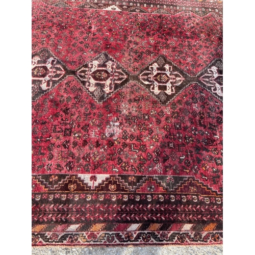 316 - A large red oriental pattern rug 305x 215