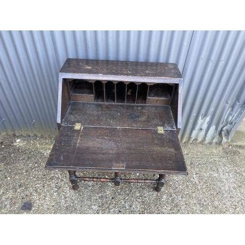 145 - An early oak three drawer bureau