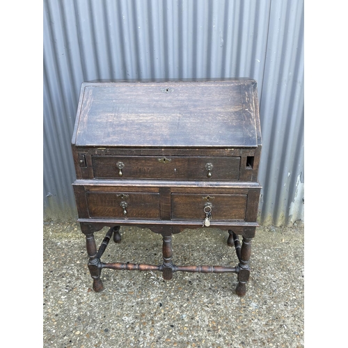 145 - An early oak three drawer bureau