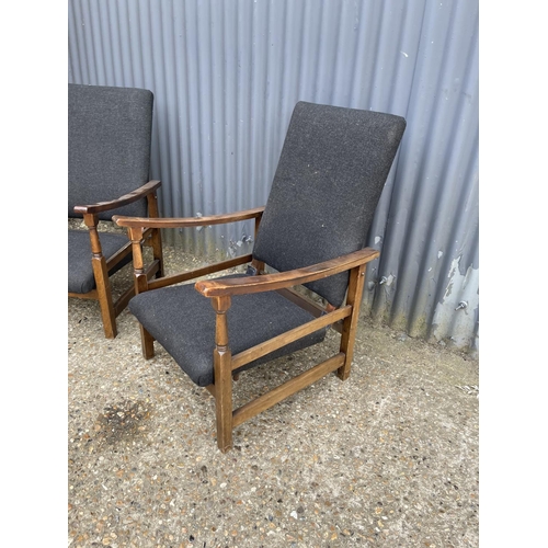 179 - A pair of oak framed reclining easy chairs upholstered in black