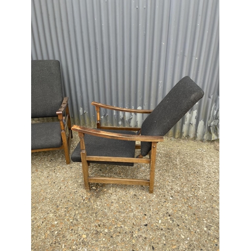 179 - A pair of oak framed reclining easy chairs upholstered in black