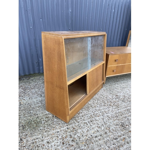 20 - A mid century light oak bookcase together with a similar style mid century two drawer dressing table