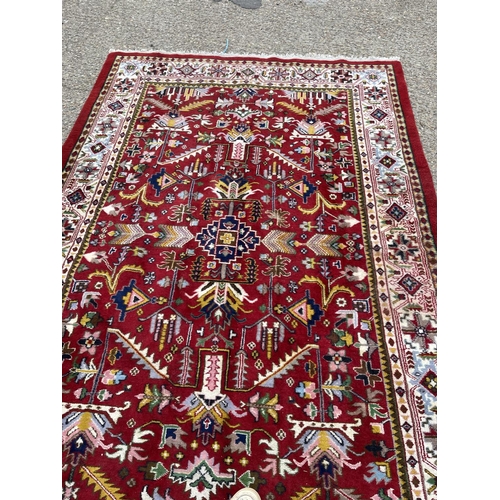 205 - A large red oriental pattern rug 195x300