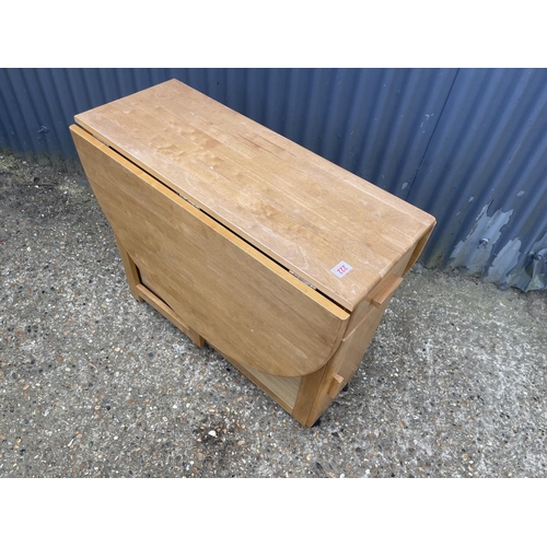 222 - A drop leaf kitchen table with storage