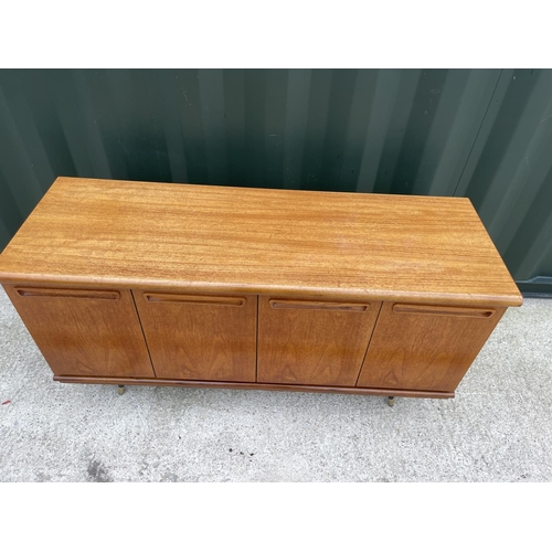 285 - A mid century teak four door sideboard raised on black and gold splayed legs 135x47 x 70