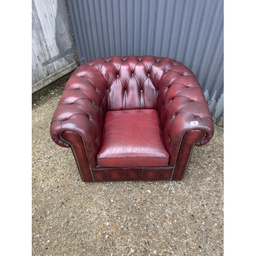 34 - An ox blood red leather chesterfield club chair