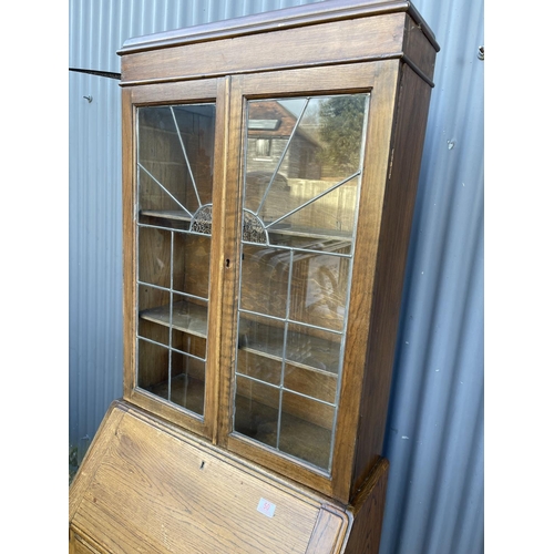 50 - An oak bureau bookcase with leaded glass top