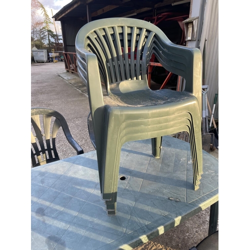 67 - A green plastic garden table together with 8 stacking chairs