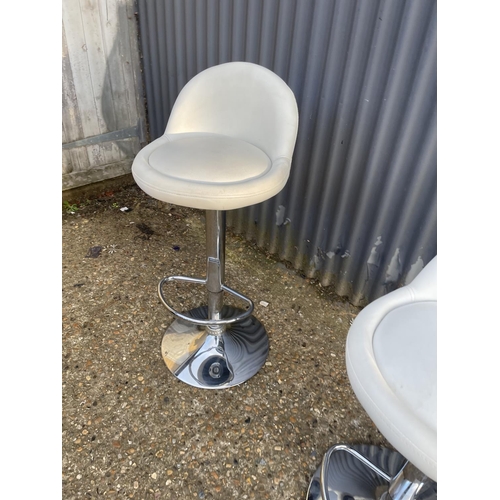 73 - A pair of modern gas lift chrome and white bar stools