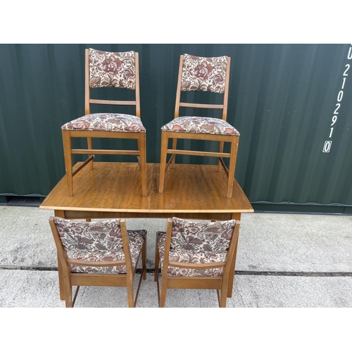 311 - A mid century teak extending dining table and four matching chairs