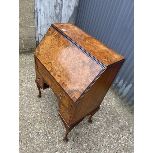 100 - A walnut bureau desk with three drawers around kneehole