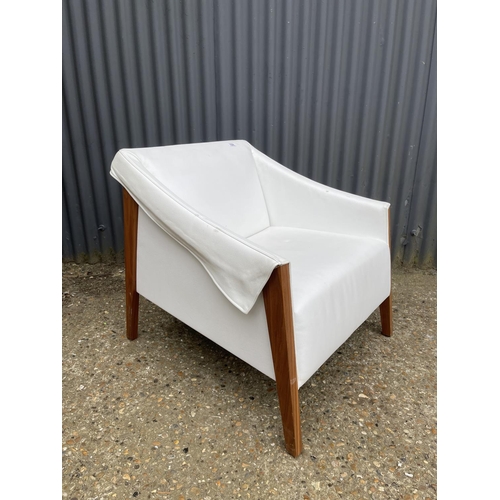 104 - A designer cream leather and teak armchair by PORADA