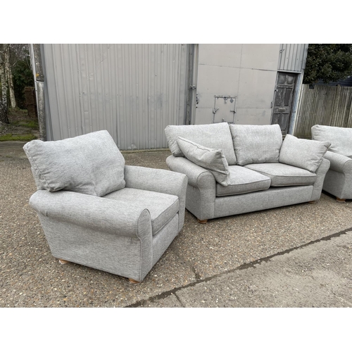 125 - A modern grey upholstered three piece lounge suite consisting on three seater sofa and two armchairs... 