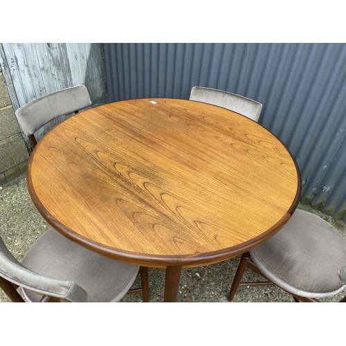 2 - A g plan teak circular dining table together with four circular seated chairs with cross stretcher