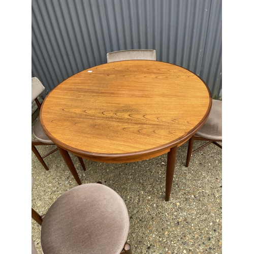 2 - A g plan teak circular dining table together with four circular seated chairs with cross stretcher