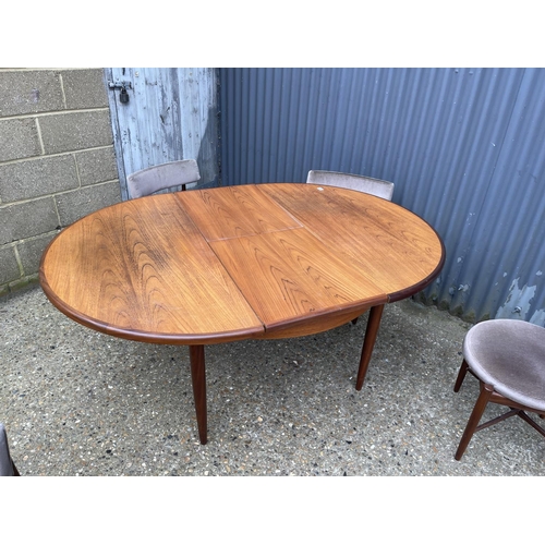 2 - A g plan teak circular dining table together with four circular seated chairs with cross stretcher