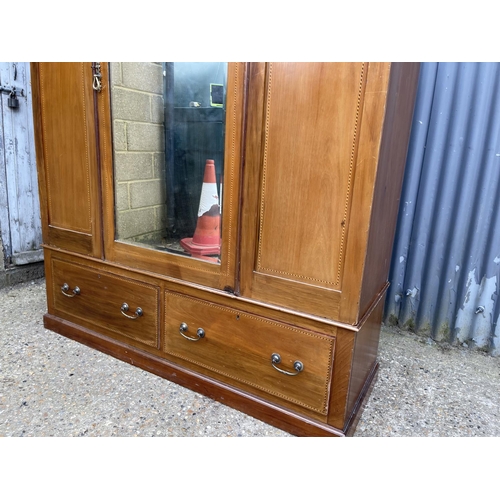 20 - An Edwardian mahogany inlaid wardrobe with mirror door 153 x52x197