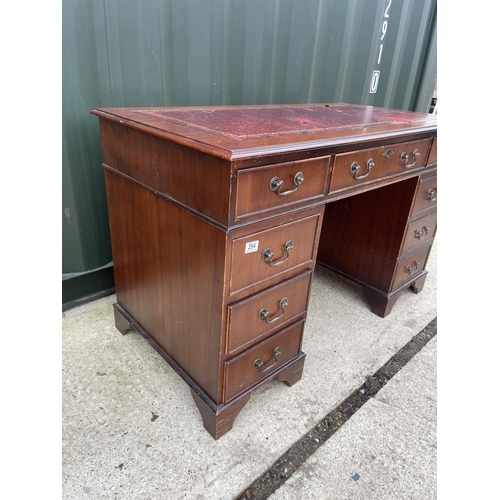 294 - A reproduction mahogany pedestal desk with red leather top