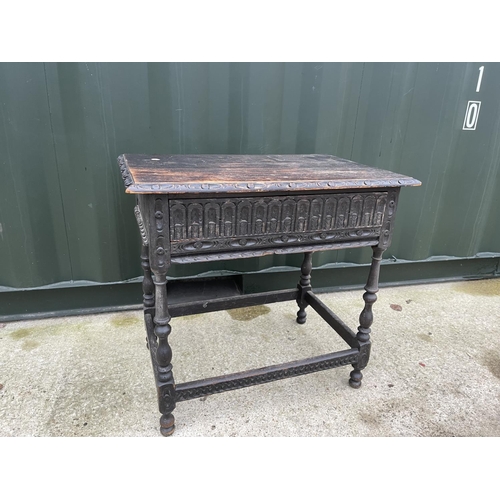 344 - A carved oak table with drawer